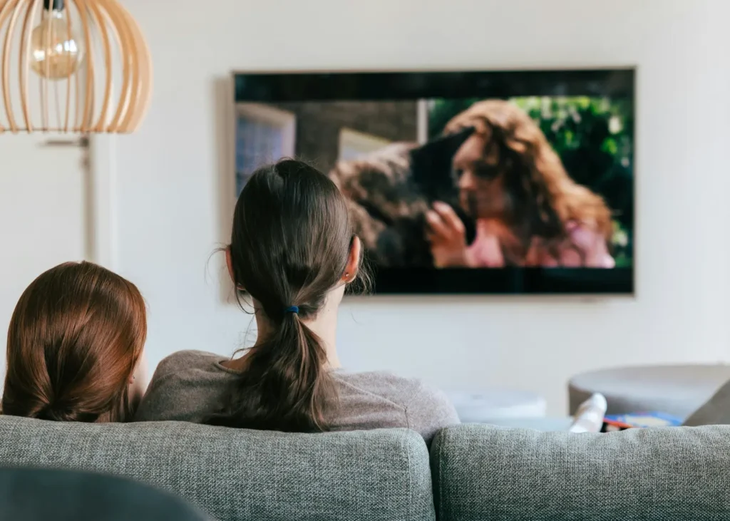 Deux personnes regardant la télévision à la maison, confortablement installées grâce à une alimentation solaire