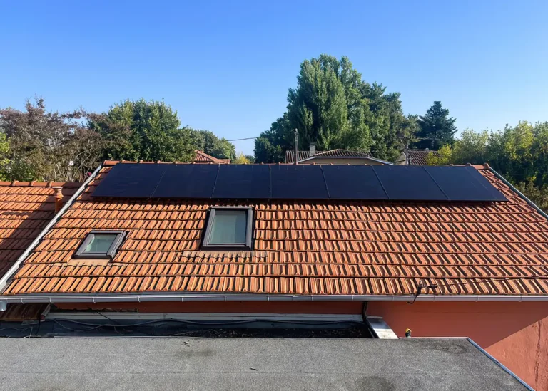 Panneaux solaires photovoltaïques installés sur toiture en tuiles rouges avec fenêtres de toit
