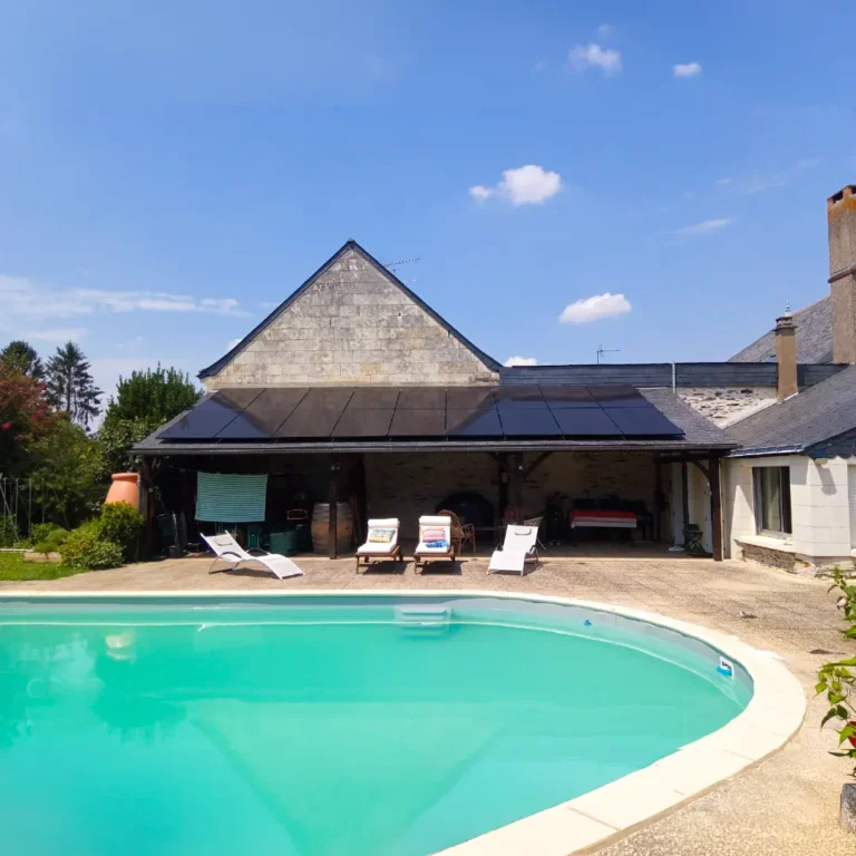 Panneaux solaires noirs installés sur l'auvent d'une maison en pierre avec piscine à Mazé-Milon, Maine-et-Loire